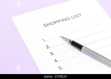 Silver pen lies on Checklist form, Shopping list of purple color. Stock Photo