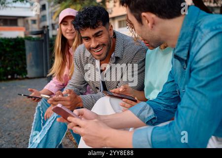 Friends enjoying time together while using smartphones Stock Photo