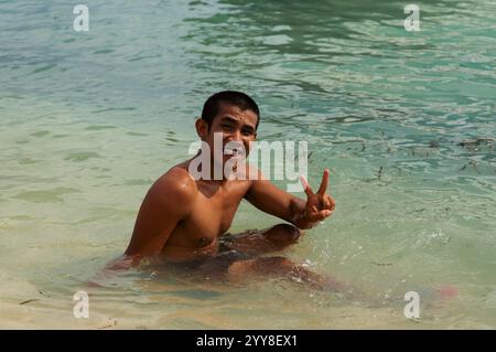 Indonesian young man swimming in the ocean Stock Photo
