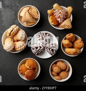 Assorted baked goods arranged in bowls on a dark surface for a festive gathering at a cozy kitchen Stock Photo