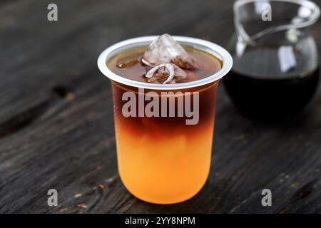 Iced Americano Coffee with Orange Juice in Plastic Disposable Cup Stock Photo