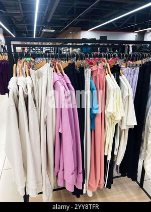 a clothing rack filled with various colorful garments on hangers in a ...