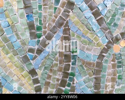 A close-up view of a colorful mosaic artwork with shades of green, blue, and yellow. The intricate pattern showcases the beauty of handcrafted tile Stock Photo