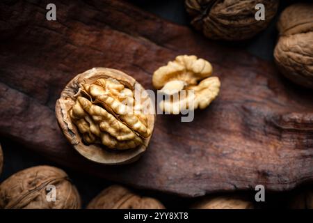 Cracked walnut with kernels on old wooden plank close up. Food photography Stock Photo