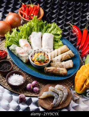 🥢✨ A perfect balance of crisp and fresh! 🥭🔥 This vibrant Vietnamese platter features crispy fried spring rolls, fresh shrimp rice paper rolls, and Stock Photo