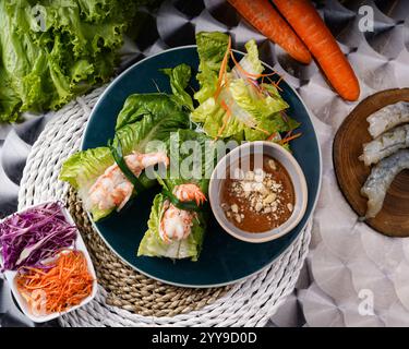 A delicious Vietnamese appetizer duo: crispy fried fish cakes and fresh shrimp spring rolls, served with vibrant salad greens for a refreshing crunch Stock Photo