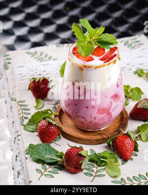 A refreshing strawberry and cream drink, beautifully garnished with fresh mint leaves and caramelized sugar, creating the perfect balance of sweetnes Stock Photo