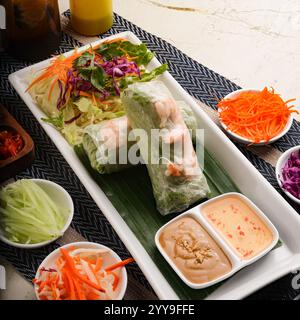 Fresh Vietnamese spring rolls packed with vermicelli noodles, crisp vegetables, and shrimp, served with a savory peanut dipping sauc Stock Photo