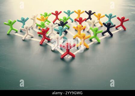 Team work organizational chart concept, colorful dolls on blackboard. Stock Photo
