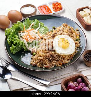 A vibrant plate of Vietnamese fried rice served on a banana leaf, bursting with savory flavor, crisp vegetables, and topped with aromatic herbs Stock Photo