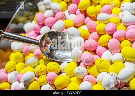 background of multi-colored chocolate eggs covered with icing with a spoon for soaking. Easter, Easter eggs Stock Photo
