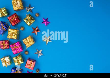 Colorful gift boxes and ornamental stars arranged against a bright blue background, perfect for holiday and festive greeting cards. Stock Photo