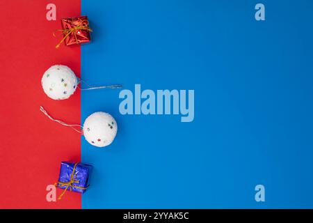 Brightly colored festive decorations with glittery star-studded ornaments and wrapped gifts positioned on a blue and red joyful background, perfect fo Stock Photo