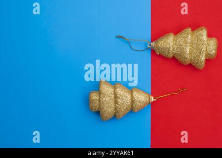 Elegant golden glitter Christmas tree decorations displayed on a blue and red split background. Perfect for holiday themes, festive celebrations, and Stock Photo
