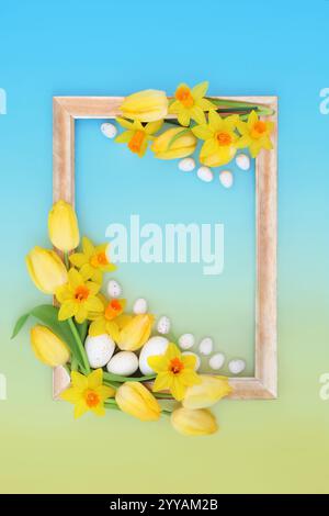 Floral Easter background frame design concept, eggs, spring flowers, gold frame. Seasonal symbols edible sweet food candy for holiday season. Stock Photo