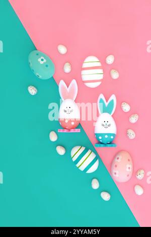 Easter bunny and eggs abstract composition. Fun symbols edible sweet food candy design for holiday season on pink blue diagonal background. Stock Photo