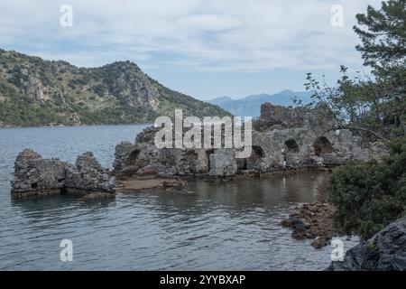 Cleopatra Bath Ruins Fethiye Turkey partially submerged in the calm waters of a picturesque bay. The stone walls, eroded by time and the elements. Stock Photo