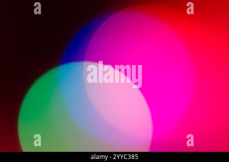 Circles of light converging in multiple colors in an abstract background Stock Photo
