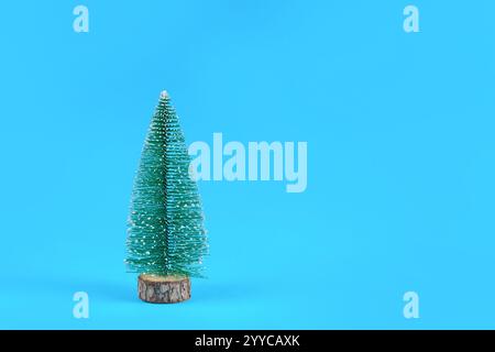 Small Christmas tree isolated on a classic blue background in a studio. Christmas and minimalism concept with copy space for text or design Stock Photo