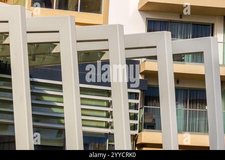 Curved balconies of a modern building showcasing contemporary architectural design against bright daylight. Stock Photo