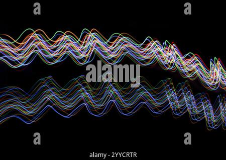 A long exposure photograph. Light painting photography with vibrant multi color lights against a black background. Stock Photo