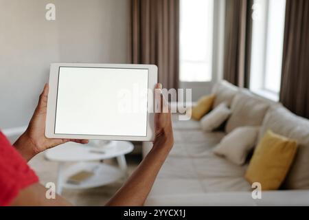Medium close up of unrecognizable female hands holding white rectangular tablet with total white screen Stock Photo