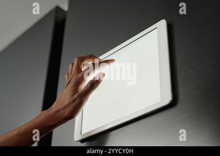 Low angle shot of unrecognizable female hand touching screen of tablet on fridge door Stock Photo