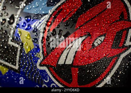 "A close-up of a colorful soda can covered in water droplets, with contrasting red, blue, and black patterns creating a modern, dynamic feel. The dewd Stock Photo