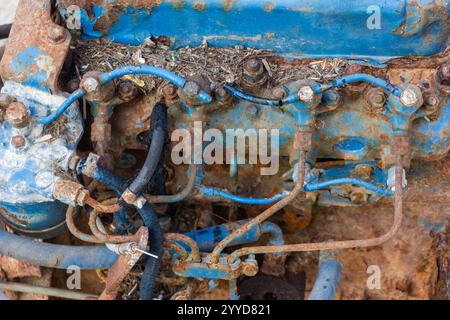 Rusty Blue Mechanical Engine Component with Hoses and Connectors in Close-Up View Stock Photo