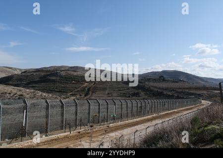 Majdal Shams, Israel. 20th Dec, 2024. A view of the Israeli fence on the border with Syria (left), adjacent to the Druze village of Majdal Shams (right), located in the Israeli controlled Golan Heights. Credit: Nir Alon/Alamy Live News Stock Photo