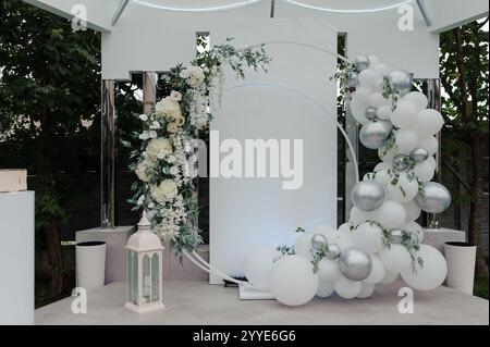 Elegant Wedding Ceremony Backdrop with Floral Arrangements and Balloon Decorations. Stock Photo