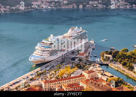 25 October 2024, Kotor, Montenegro: Large cruise ship docking at port in beautiful coastal town, offering breathtaking view of cityscape and seascape Stock Photo