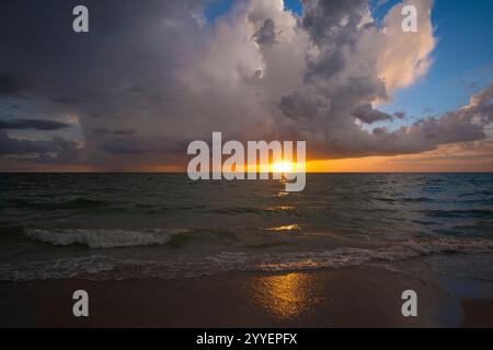 Sunset landscape of dark ominous rainstorm with lightning and thunder over sea water waves. Beautiful seascape in evening Stock Photo