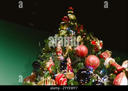A Christmas tree with many ornaments on it. The tree is lit up with lights. There are many different colored ornaments on the tree Stock Photo