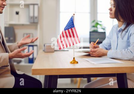 Man sitting in office of US public services or embassy having consular visa interview with official Stock Photo