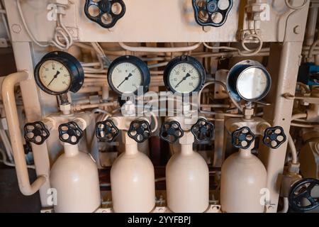 Complex control panel featuring valves, gauges, and tanks, highlighting industrial processes and monitoring systems Stock Photo