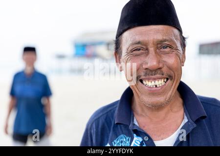Portrait of a smiling bajau man with traditional hat in a small village in the middle of a sea near Sulawesi, Indonesia Stock Photo
