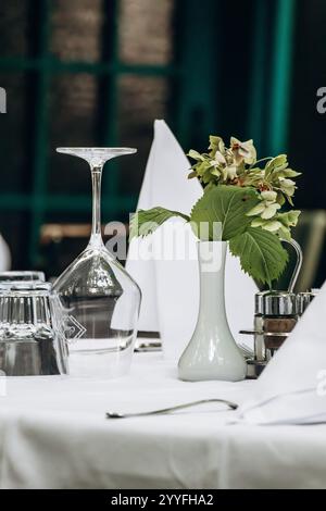 Elegantly Set Table with a White Tablecloth in a Restaurant Stock Photo