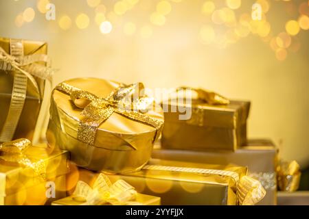 Golden gift boxes on glittering blurred golden background. Symbol of happiness and holidays. Stock Photo