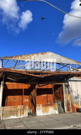 A warehouse with a loading ramp after a fire. Burnt metal frame of the ...