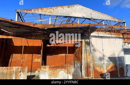 A warehouse with a loading ramp after a fire. Burnt metal frame of the ...