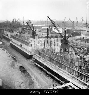 'Phoenix' concrete caissons, part of the Mulberry artificial harbour, being constructed in Surrey Docks in Rotherhithe, London, 17 April 1944 Stock Photo