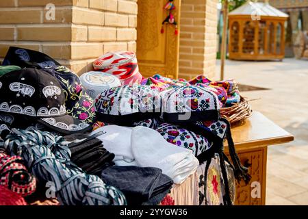 Ethnic colorful traditional hat tubiteika and bags with traditional uzbek ornament on street market in Khiva, Uzbekistan, Central Asia. Stock Photo