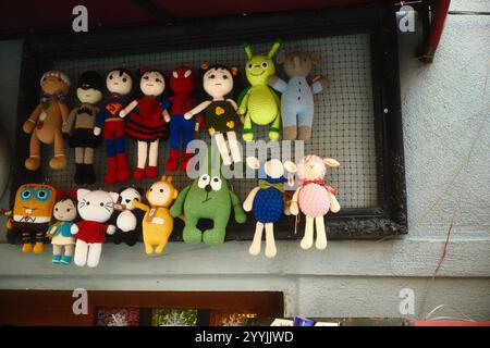 Balat, Istanbul, Turkey - December 1, 2024: Handcrafted crocheted wool dolls of various colorful and cute characters hanging as wall decoration Stock Photo