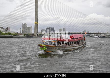 Excursion boat on the Chao Phraya River in front of the Bangkok skyline ...