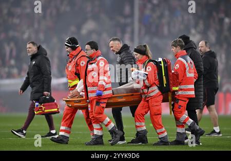 Paramedics carry a stretcher for an injured player onto the pitch ...