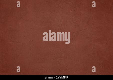 Abstract grunge background in plaster red color. Rough stucco wall painted red color. Stock Photo