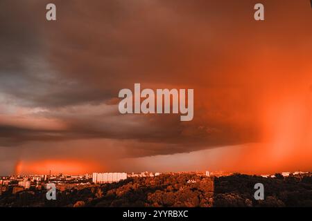 pantone 2025. rainbow appeared against gray stormy sky over residential area of the city. Stock Photo