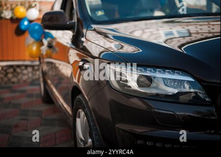 Elegant Black SUV with Reflections and Party Balloons. Stock Photo