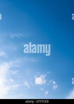 Vibrant blue sky filled with scattered, puffy white cumulus clouds. Stock Photo